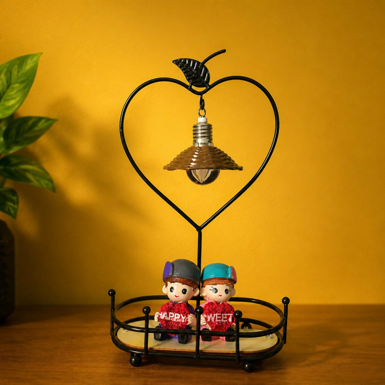 Decorative lamp featuring couple figurines and warm light