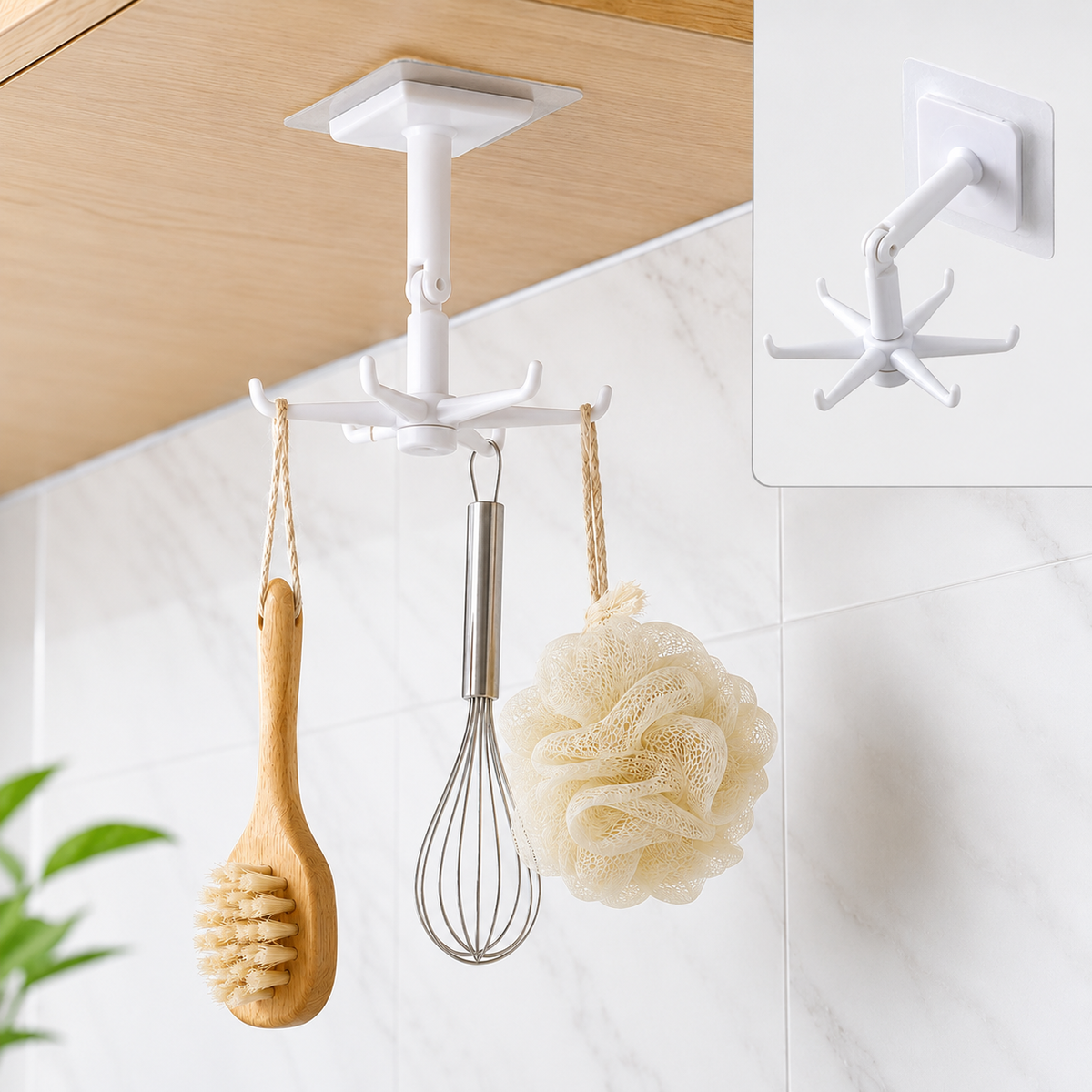 A white 360-degree rotating hook with six prongs hangs from a wooden cabinet, holding a wooden brush, whisk, and loofah.