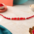 White Thread Rakhi with Smooth Red Oval Bead Accents