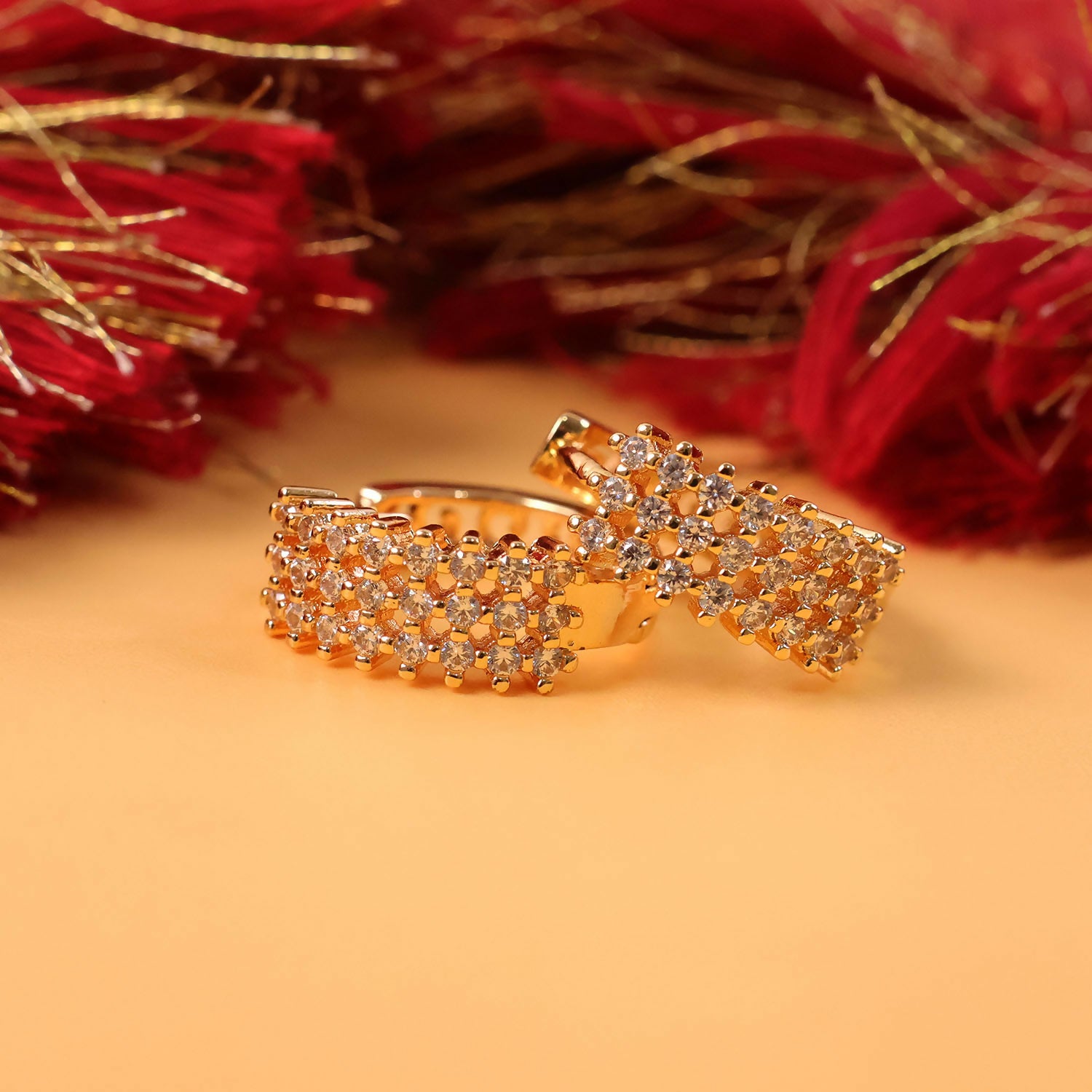 Front view of CZ studded gold-tone hoop earrings with elegant sparkle