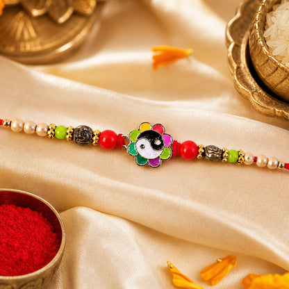 Top view of a floral enamel pearl beaded designer Rakhi with intricate details.