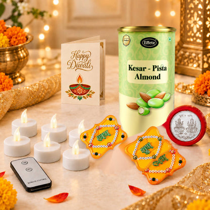 A festive arrangement featuring a tin of almonds, a Diwali card, LED tealights, gold Shubh-Labh decor, and a silver coin,