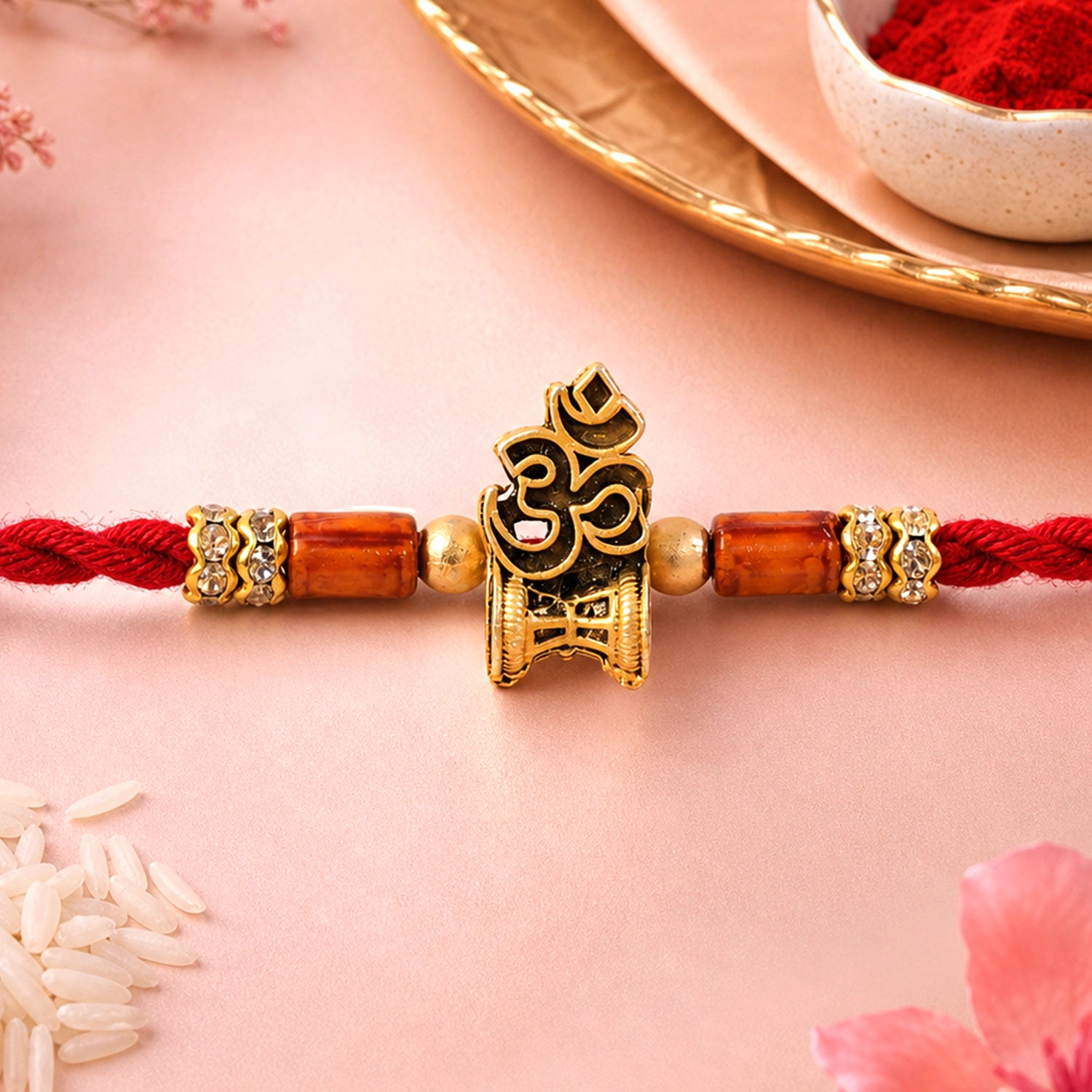 Red Braided Rakhi with Golden Om Pendant and Warm Amber Beads