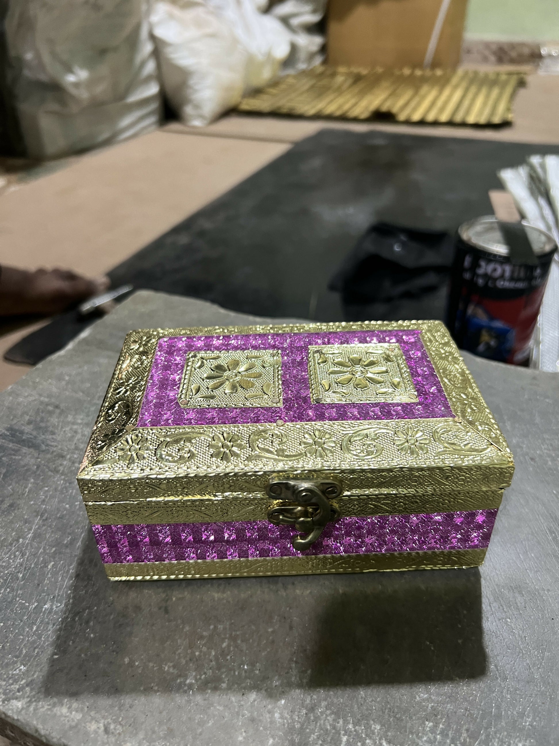 Detailed close-up of golden embossed floral pattern on glitter box