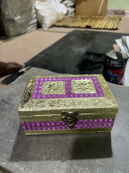 Detailed close-up of golden embossed floral pattern on glitter box