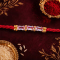 Red Thread Rakhi with a Row of Pink Baguette-Cut Crystal Beads