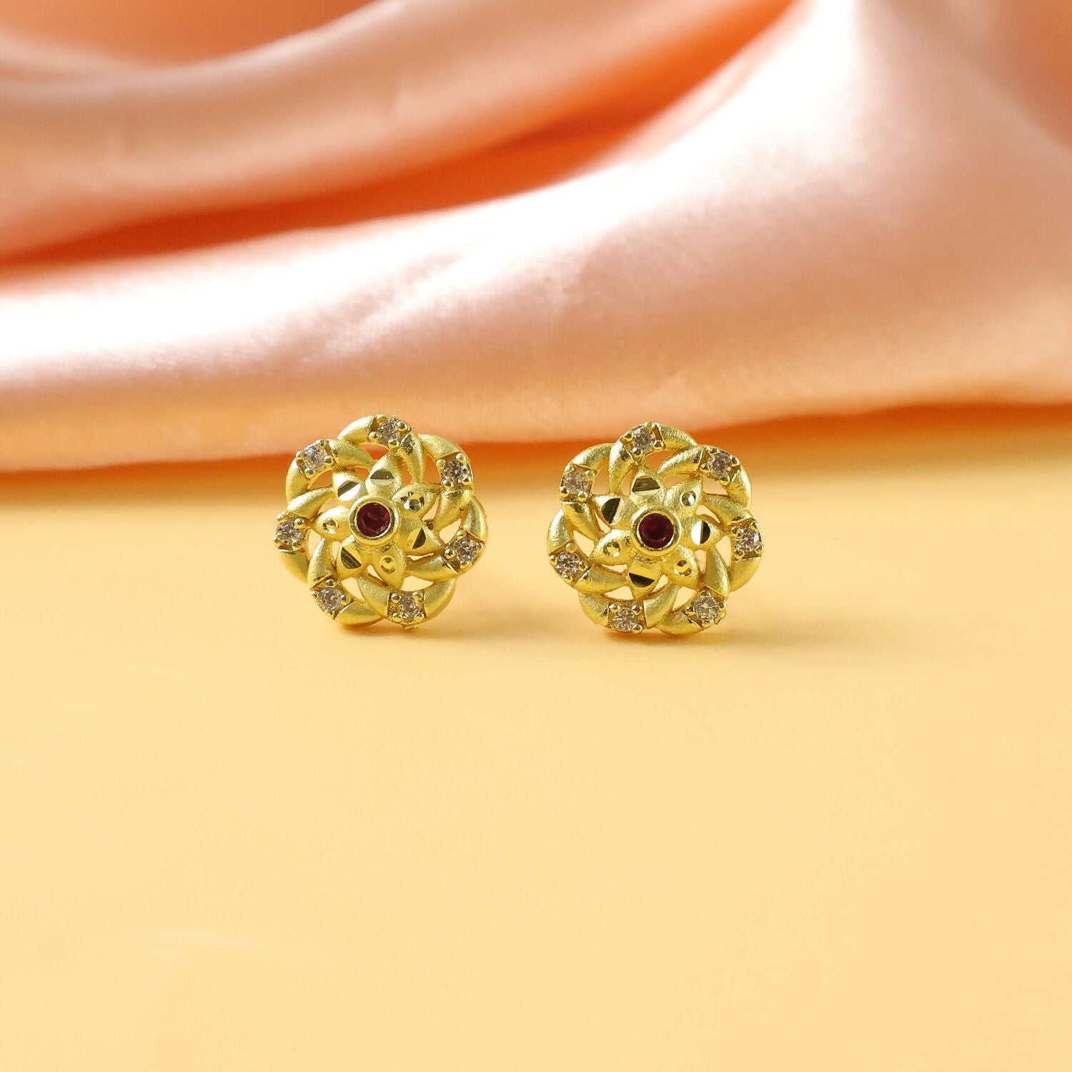 Detailed view of gold stud earrings showcasing craftsmanship and sparkling stones