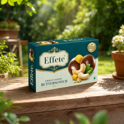 A teal box of Effete Choco Coated Butterscotch chocolates sits on a rustic wooden surface in a lush garden setting.