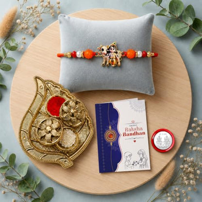 Krishna Cow Rakhi Combo with leaf design pooja thali, chocolate, roli chawal, and silver coin.