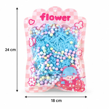 A clear bag of blue shredded paper and pastel foam balls with dimensions of 24 cm height and 18 cm width.