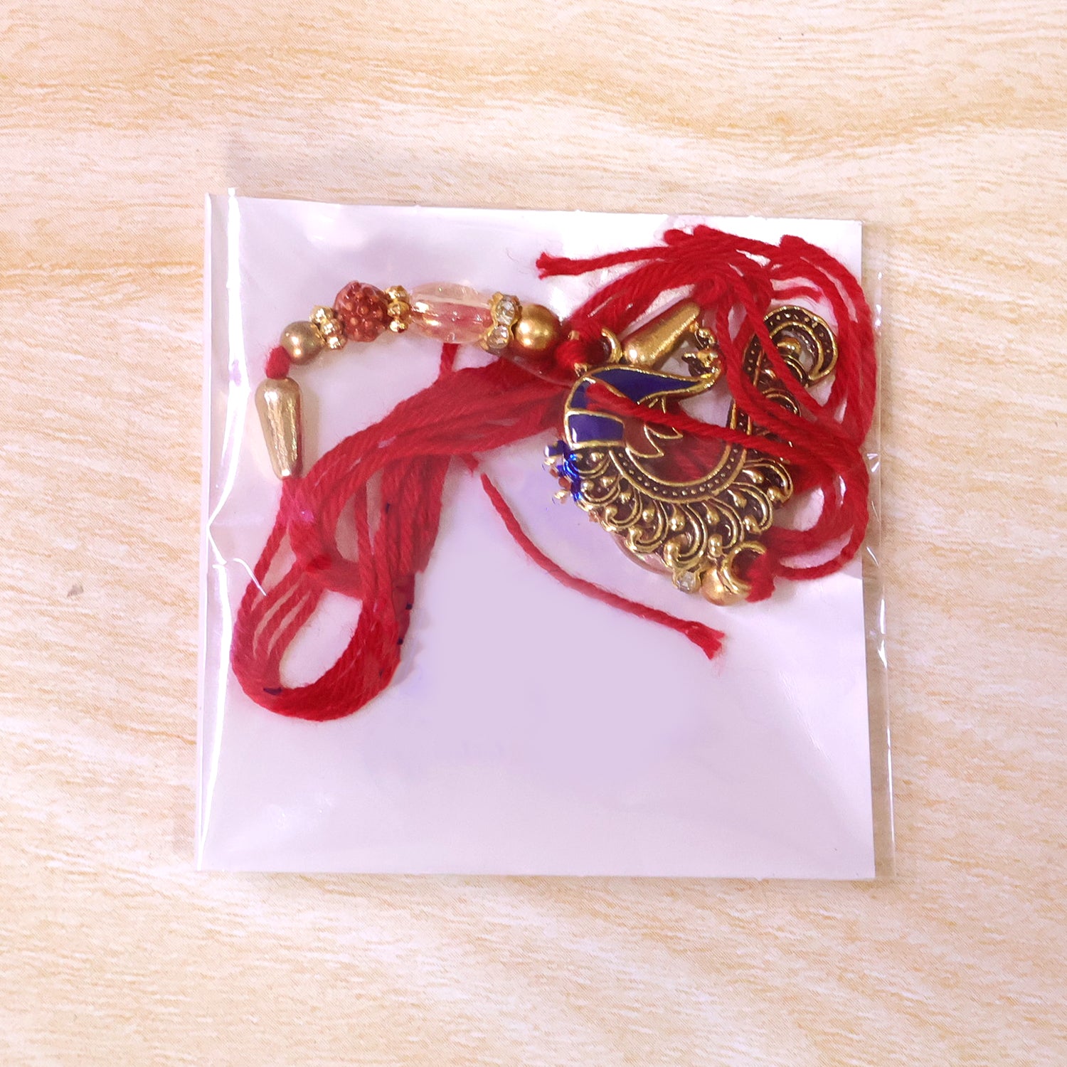 Designer Rakhi with Peacock Paisley Charm, blue stones and thread look for Gift Use