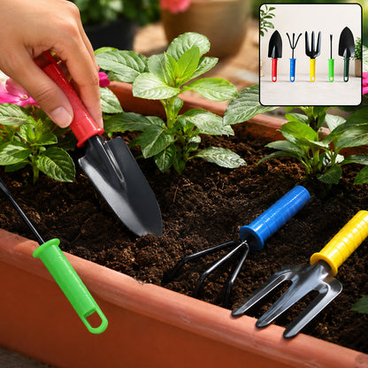 A hand holds a red-handled trowel in a planter with other colorful gardening tools and green plants.
