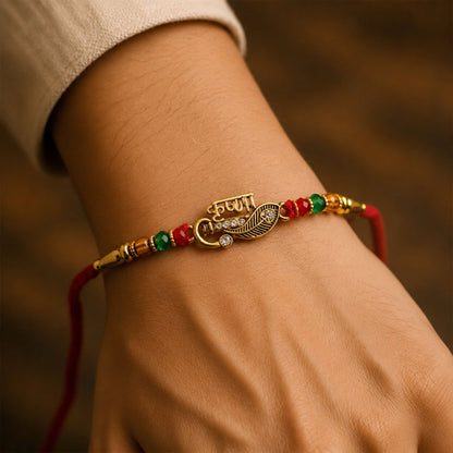 Veera Name Rakhi with Flute Leaf Style Centre, Stones and Red Green Beads