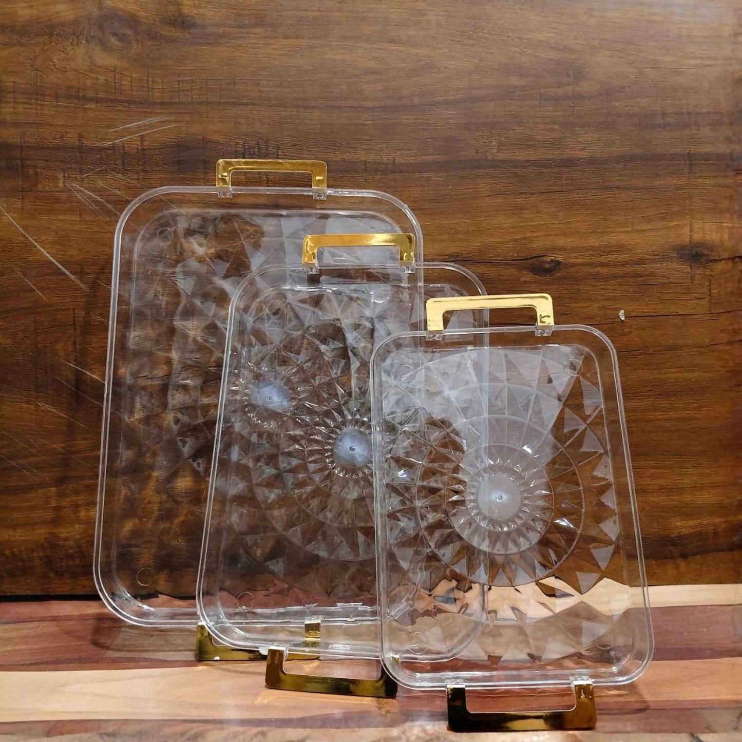 Transparent serving tray holding coffee and snacks with golden handles