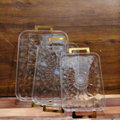 Transparent serving tray holding coffee and snacks with golden handles