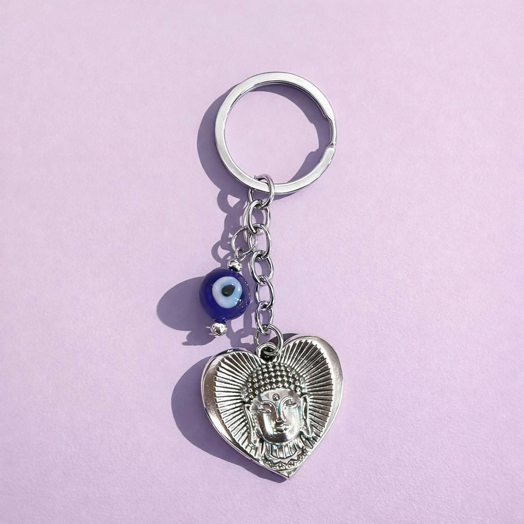 Buddha Evil Eye Heart Keychain showing Buddha face and blue evil eye bead