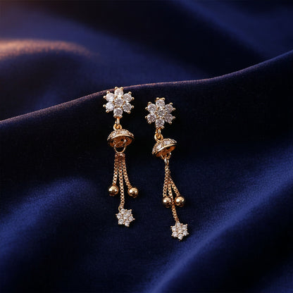 Close-up view of elegant floral crystal drop earrings with gold-tone dome and chain tassels