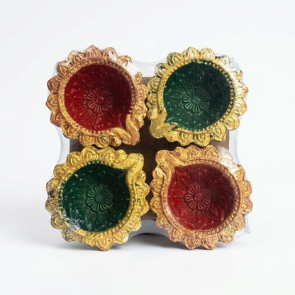 Four clay diyas, two red and two green, with gold painted edges, packaged together on a white background.