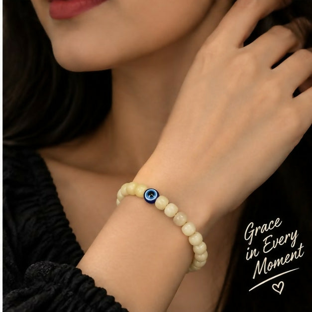 Close up of cream barrel beads and blue evil eye detail