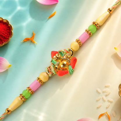 Gold Ganesha Charm Rakhi with Coral and Green Accents