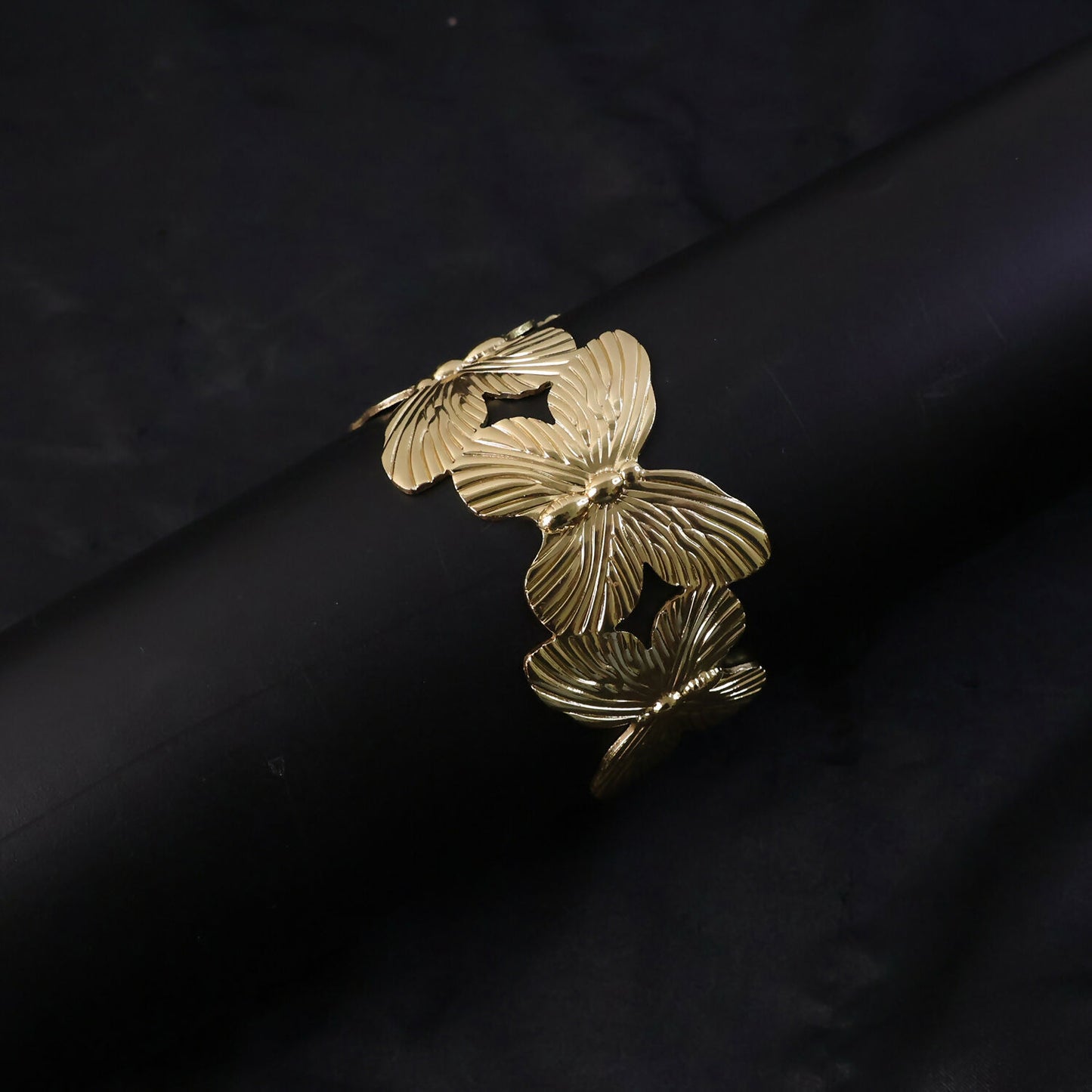 Gold plated bracelet worn on wrist showing floral motifs