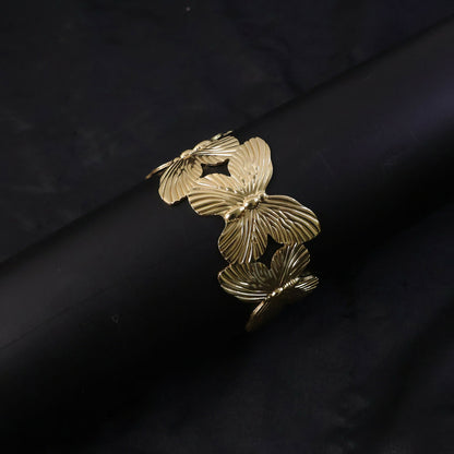 Gold plated bracelet worn on wrist showing floral motifs