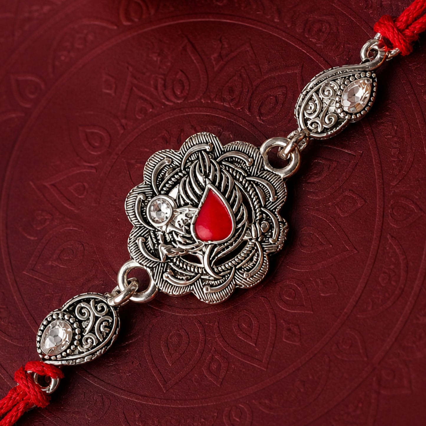 Ornate Rakhi featuring Silver Round Charm, metal trims and chain look for Gifting