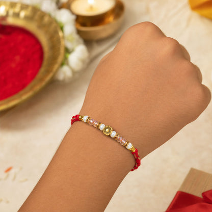 Red Thread Rakhi with Pearls, Crystal Beads and a Gold Flower Charm