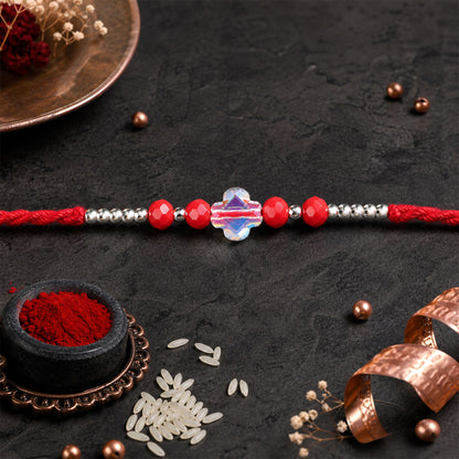 Red Thread Rakhi with Red Beads and an Iridescent Quatrefoil Crystal