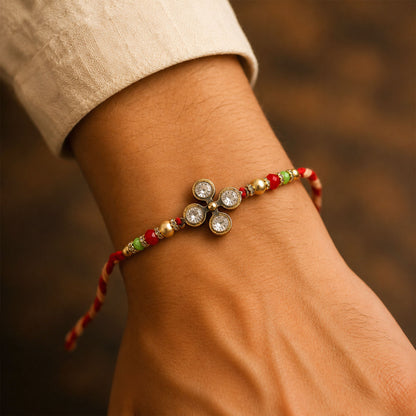 Four Crystal Clover Rakhi with Gold Bezels, Roli Chawal Coin and Floral Gift Packing
