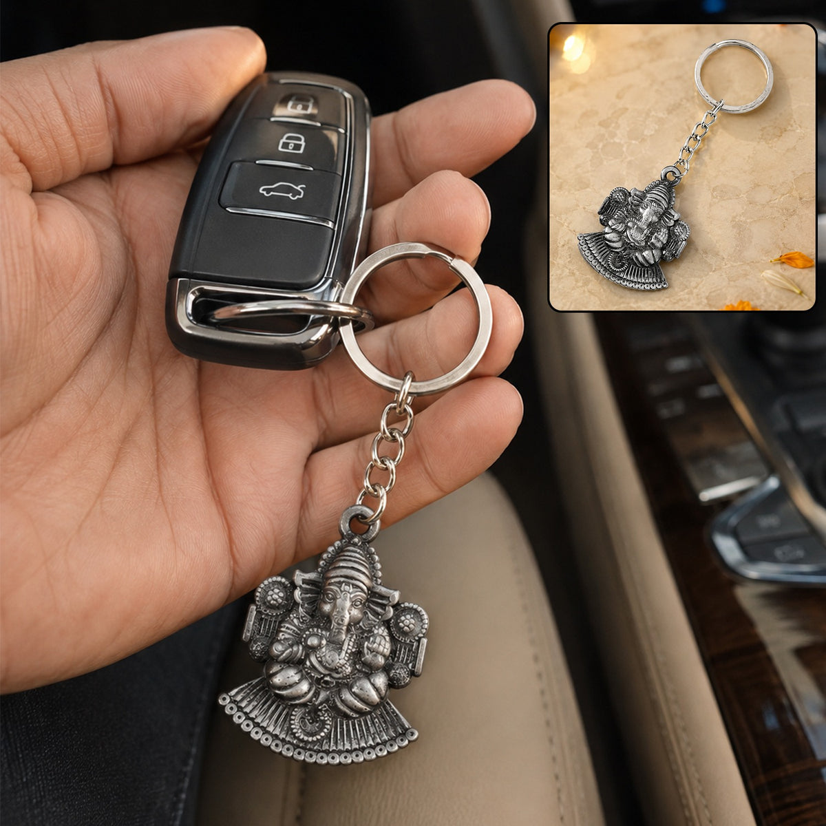 A hand holding a car key fob with the silver-colored Lord Ganesha keychain attached, inside a car.
