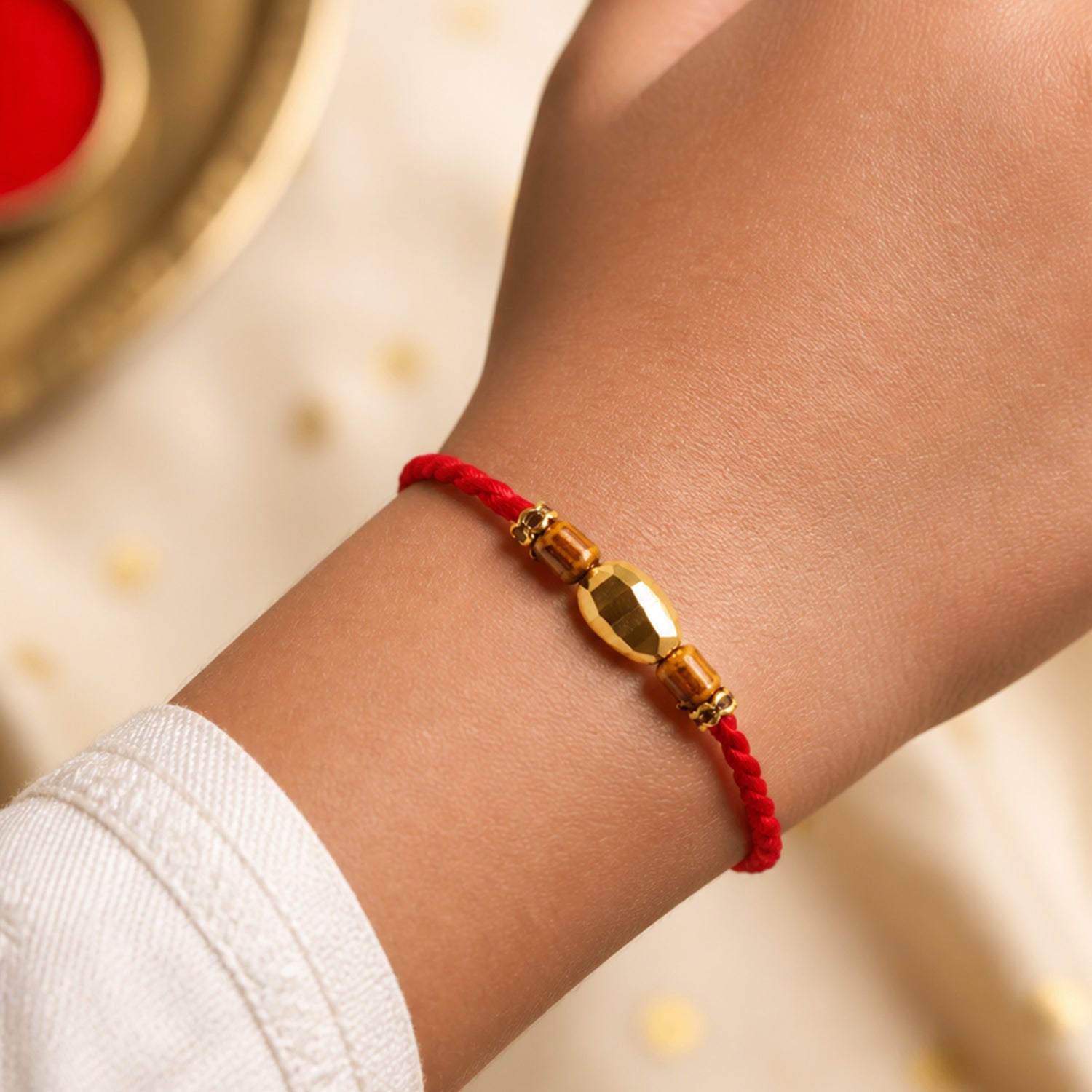 Red Thread Rakhi with Golden Oval Bead and Wooden Bead Accents