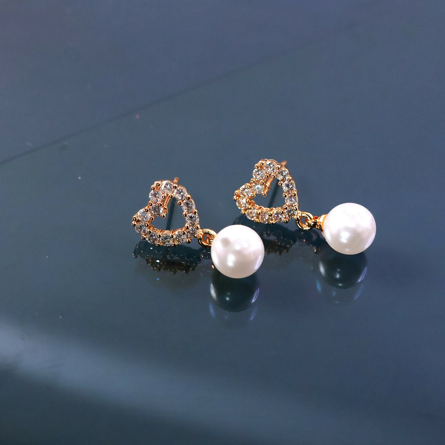 Side view of heart shape pearl earrings with delicate pearl drop accent