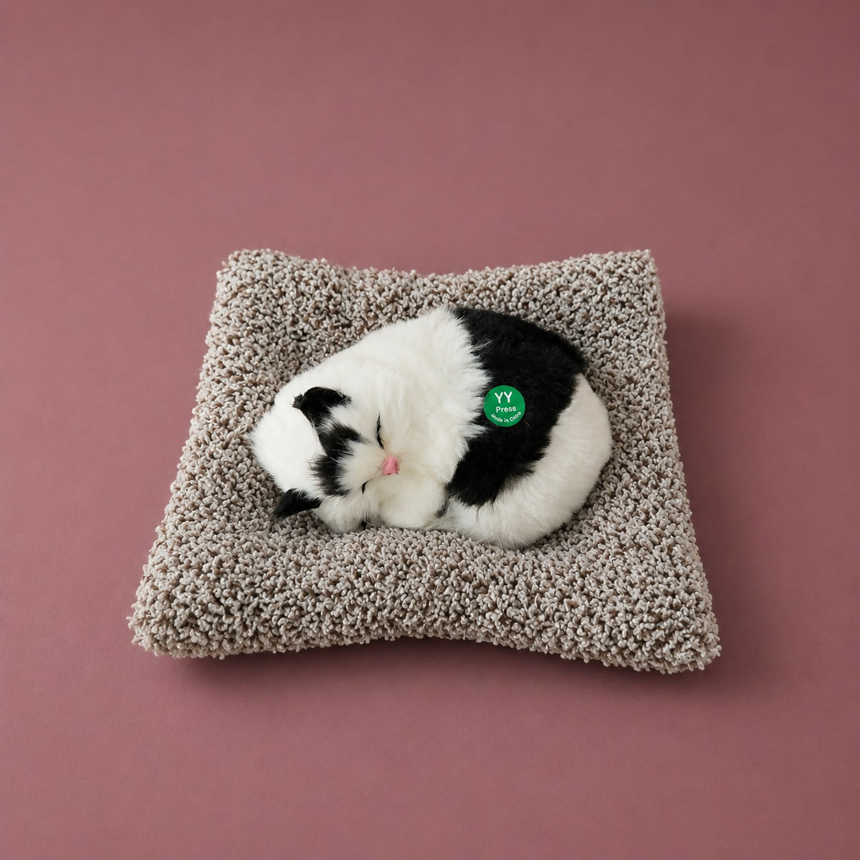 Side view of sleeping cat plush toy with cushion