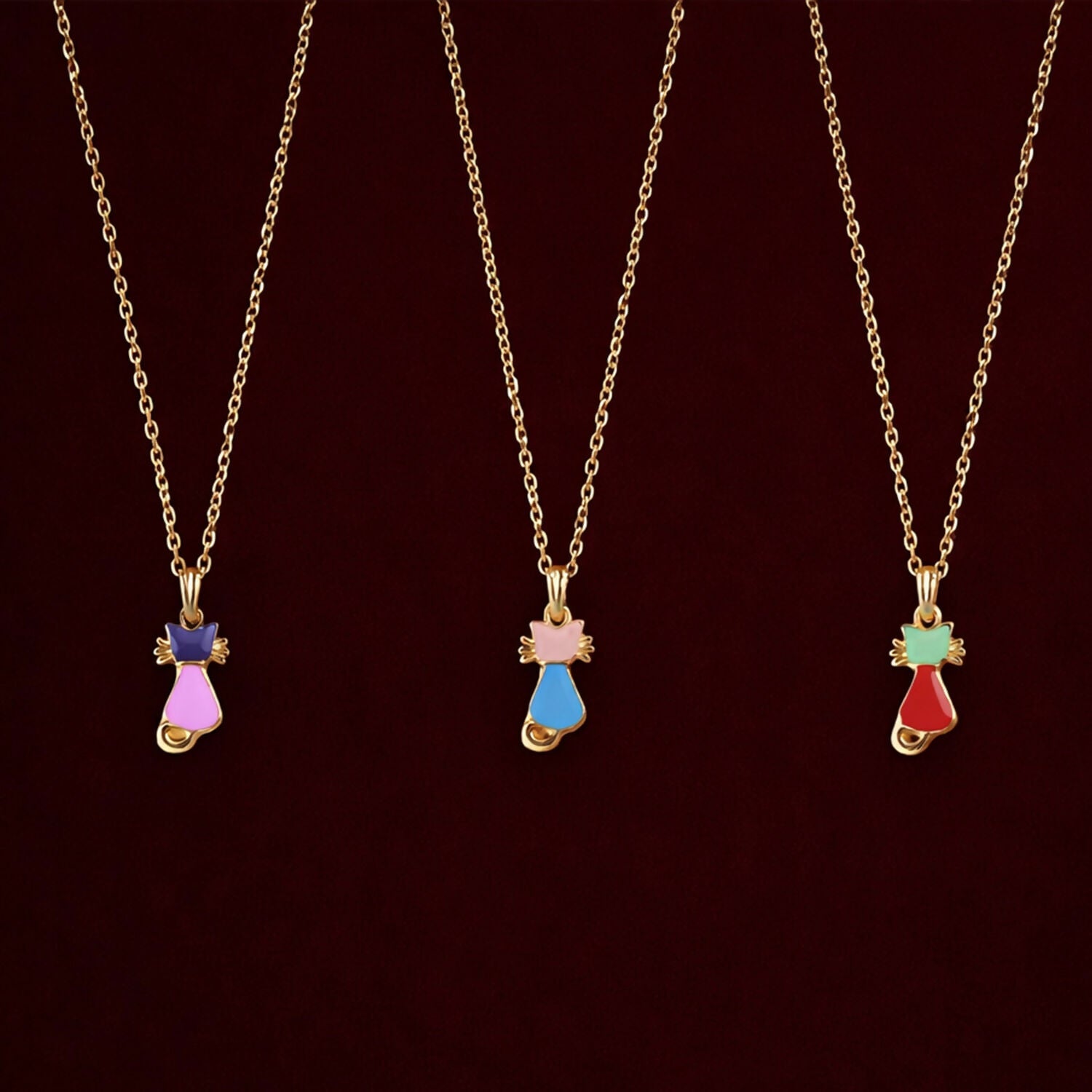 Close-up of gold cat pendant necklace showing vibrant enamel details