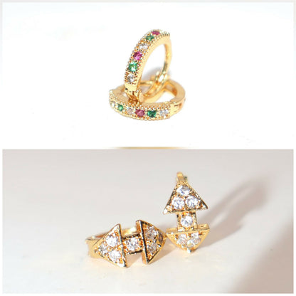 Set of two gold plated huggie hoop earrings displayed on black background