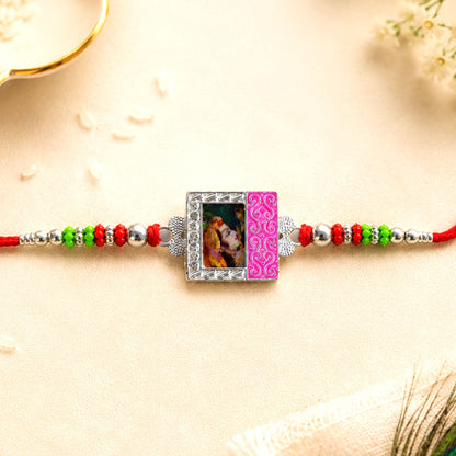 A red thread bracelet with a silver photo frame charm featuring a couple, flanked by green, red, and silver beads, rests on