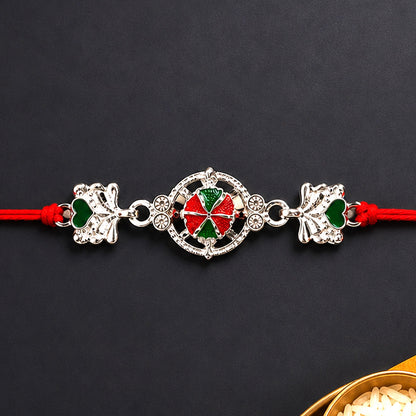 Silver Floral Rakhi with soft red thread, perfect for Raksha Bandhan.