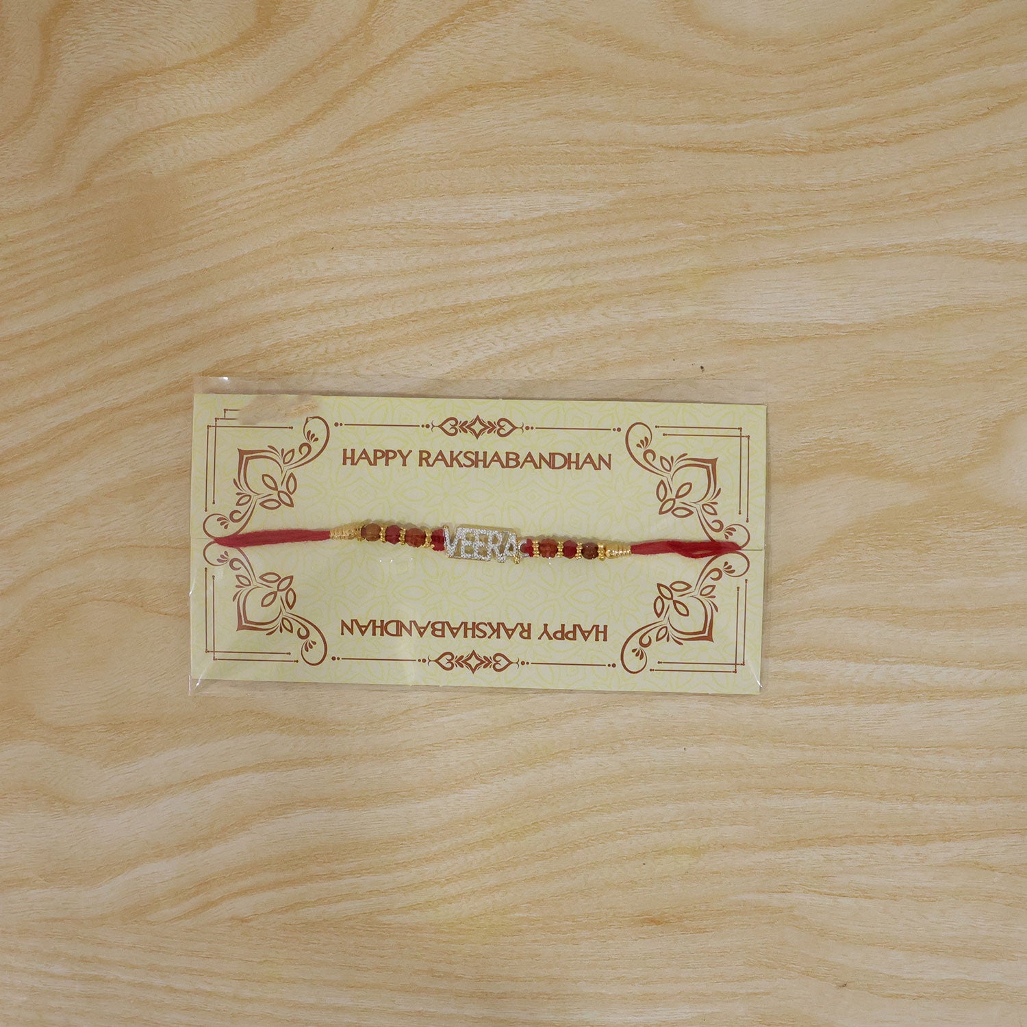 Veera Name Golden Designer Rakhi with Red Stones, Pearl Accents and Festive Beads
