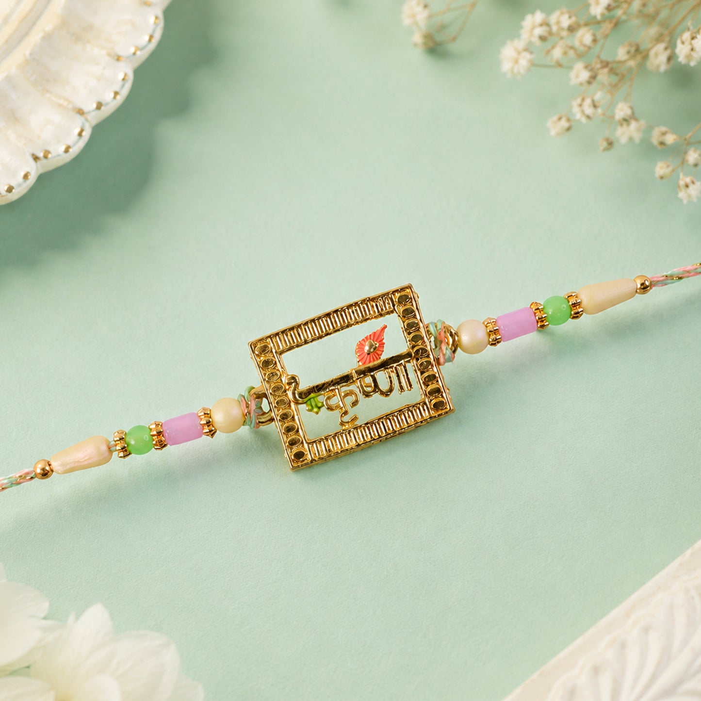 Krishna Script Pendant Rakhi with Red Flower Accent