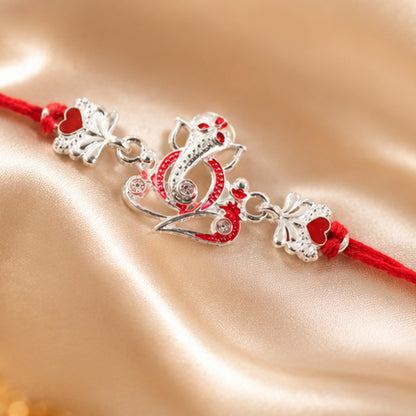 Silver Ganesha Rakhi with Red Stone Hearts and Deep Velvet Look