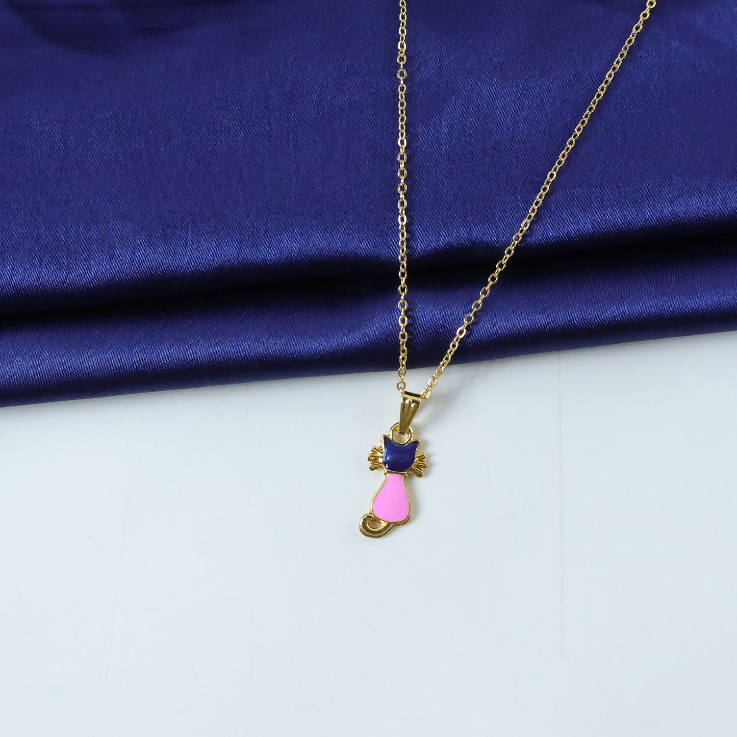 Side view of gold cat pendant with colorful enamel charm