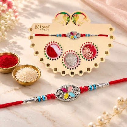 Silver Oval Floral Stone Rakhi with Color Petal Centre, Roli Chawal Coin and Card Packing