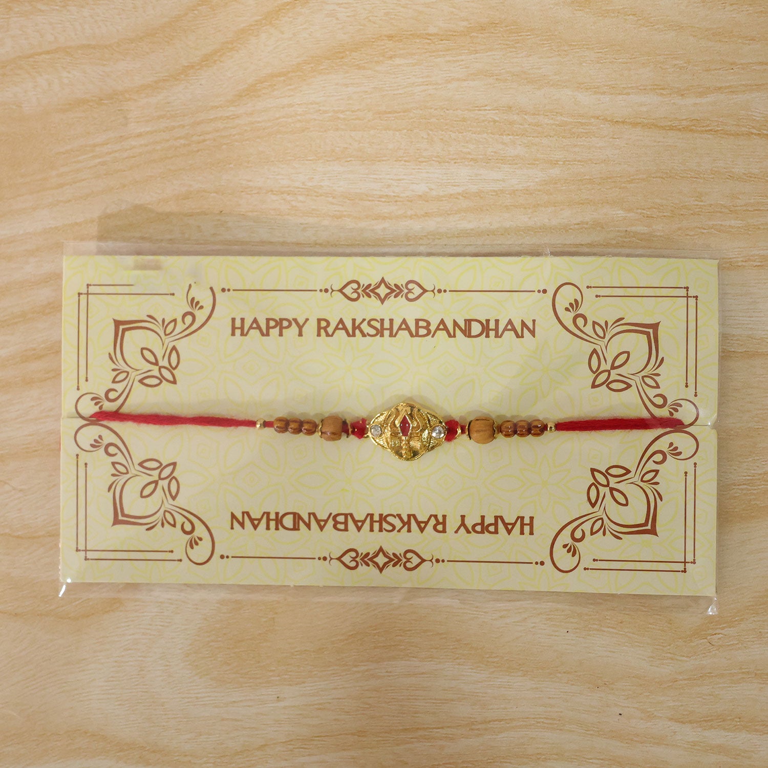 Tilak Trishul Golden Devotional Rakhi with Wooden Beads and Traditional Red Thread