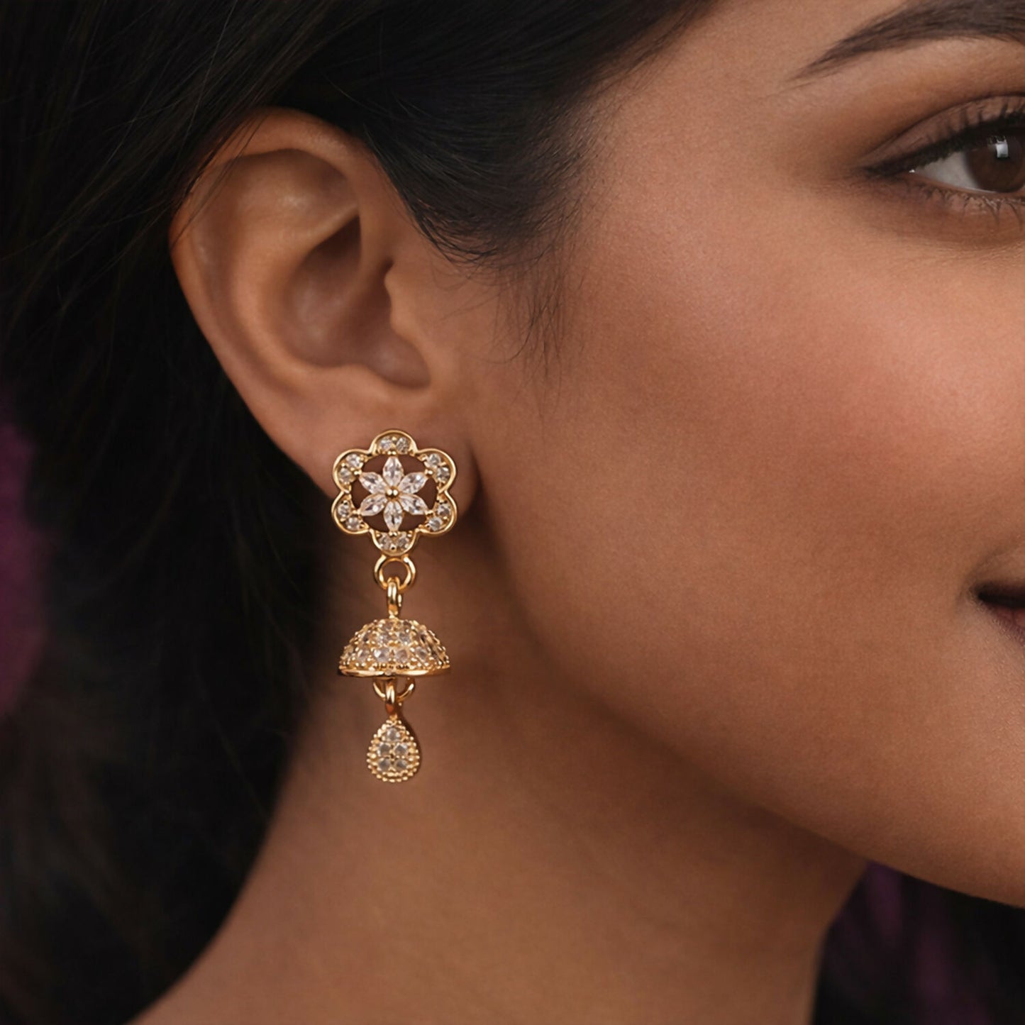 Rose gold drop earrings worn highlighting floral starburst design and crystal pavé