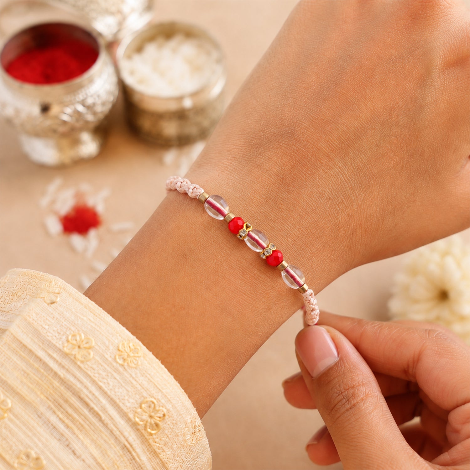 Peach Twisted Cord Rakhi with Red and Sparkling Crystal Bead Accents