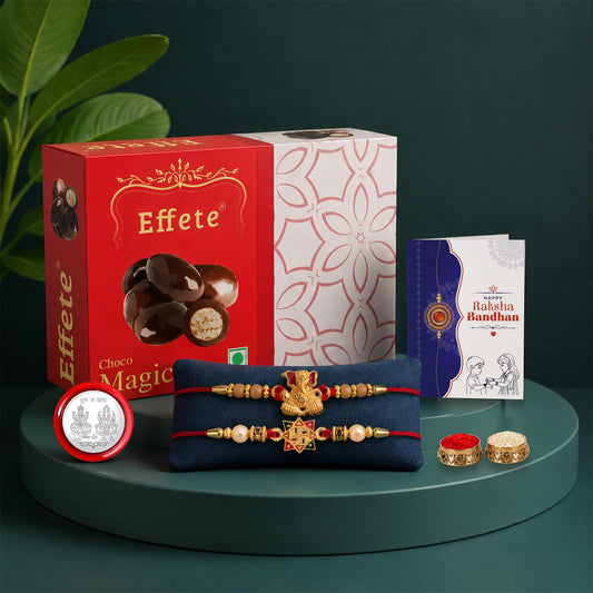 A red and white chocolate box, two red and gold Rakhis, a silver coin, a greeting card, and two small bowls of powder are