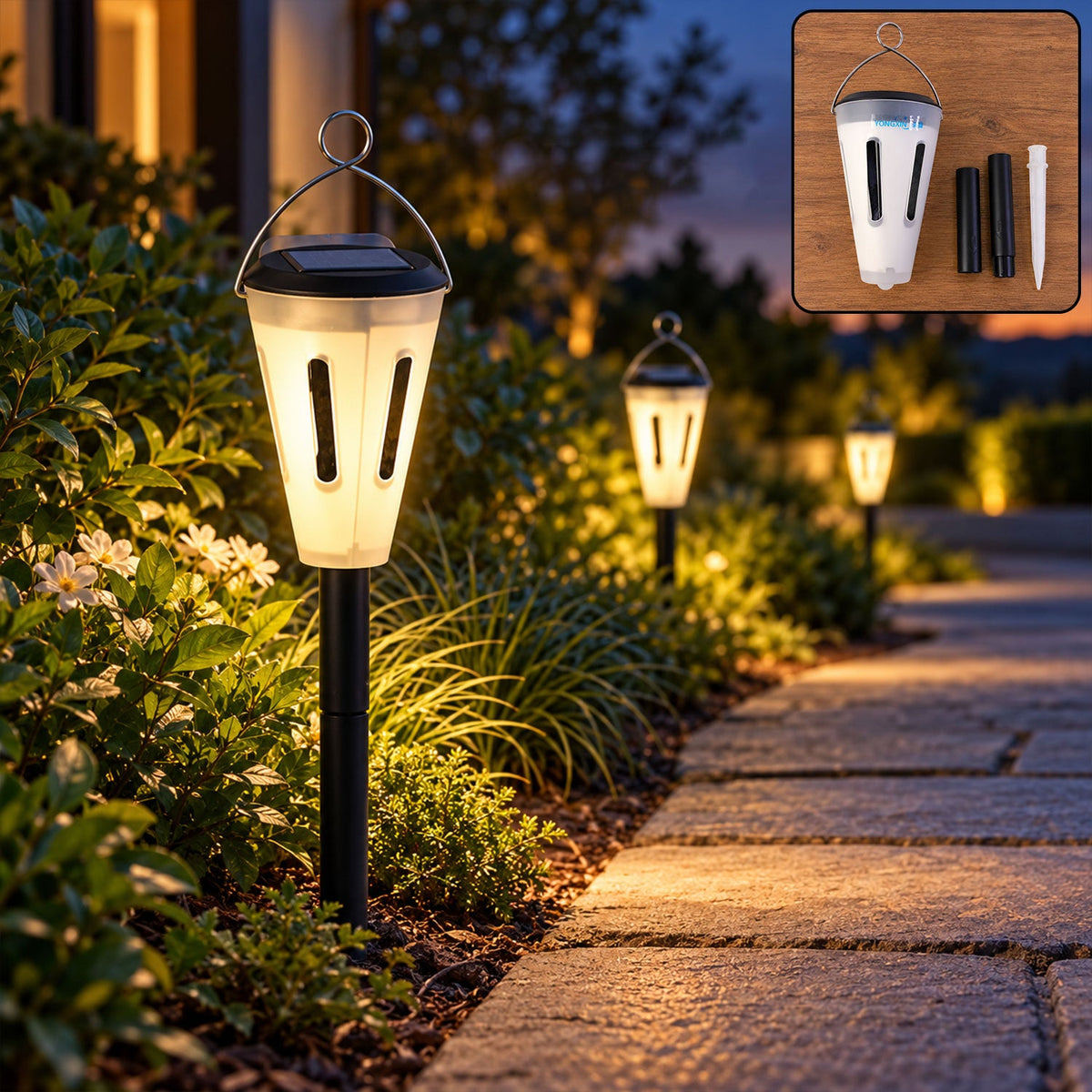 A white and black solar garden light illuminates a stone path at dusk, with two other lights glowing in the distance. An
