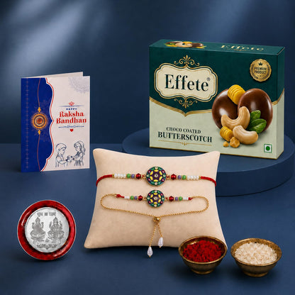 A Raksha Bandhan gift set featuring a greeting card, a box of butterscotch chocolates, two colorful bracelets, a silver