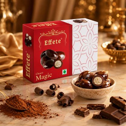 A red and white chocolate box is surrounded by scattered chocolates, cocoa powder, and chocolate bar pieces on a marble